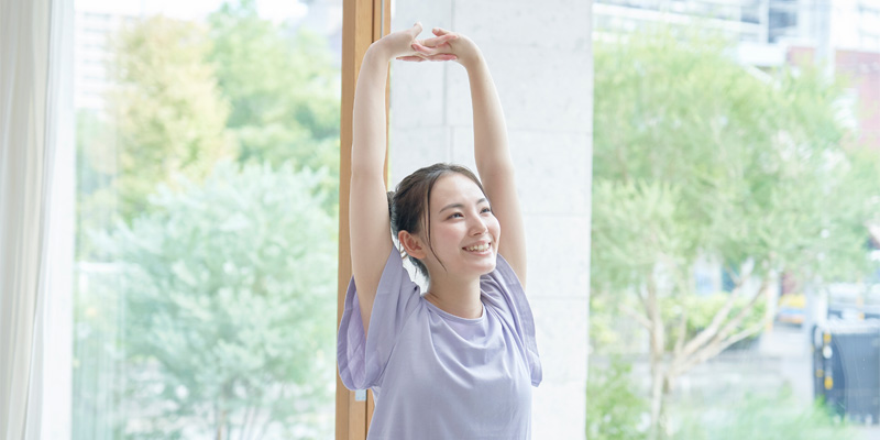 軽いストレッチを行う女性のイメージ